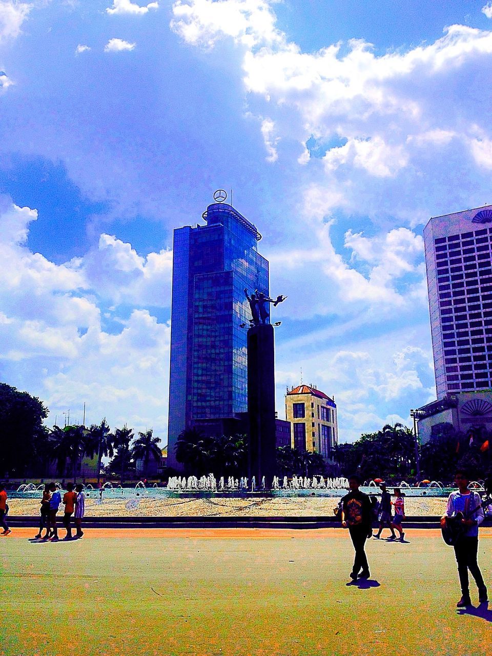 PEOPLE WALKING ON MODERN BUILDING AGAINST SKY