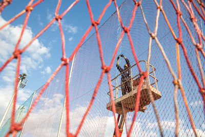 Low angle view of metal fence against sky