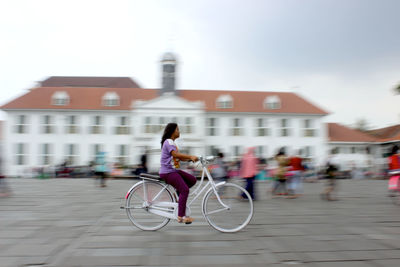 Full length of man with bicycle on street in city