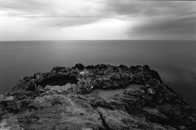 Scenic view of rocks in sea against sky