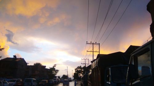 Low angle view of silhouette electricity pylon against sky during sunset