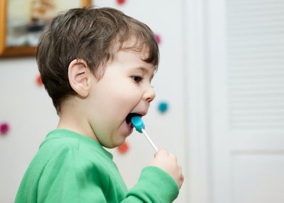 Cute baby boy enjoying a lollipop at home