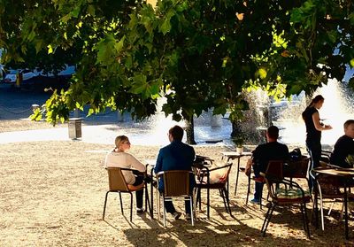 Rear view of people sitting on chair at table