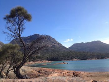 Scenic view of lake against clear blue sky