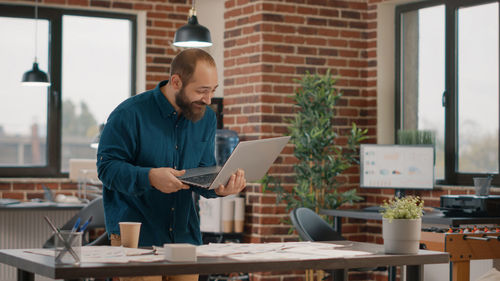 Side view of man using digital tablet in office