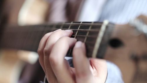 Close-up of hands playing guitar