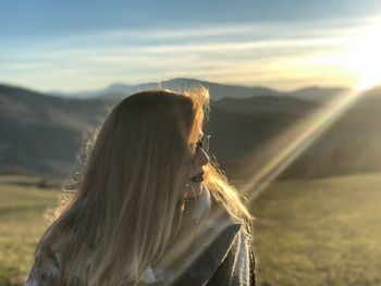 Woman looking at mountain range against sky