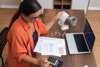 Side view of woman using calculator