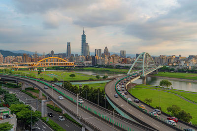 High angle view of bridge in city against cloudy sky