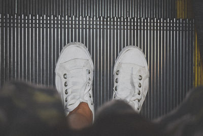 Low section of man standing on escalator