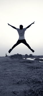 Rear view of person in sea against sky