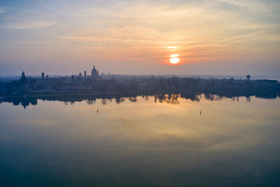 Reflection of buildings in city during sunset