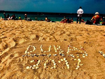 People at beach against sky