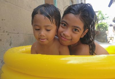 Close-up portrait of smiling boy with water in background