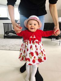 Portrait of cute girl standing with red umbrella