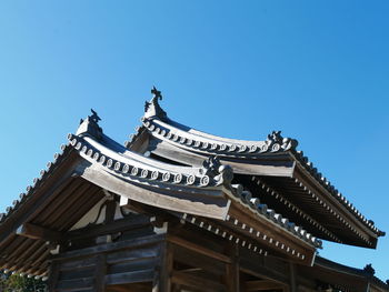 Low angle view of temple building against clear blue sky