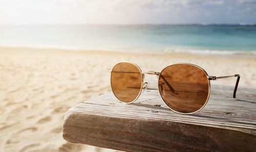 Close-up of sunglasses on beach