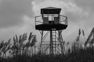 Low angle view of lookout tower on field against sky at dusk