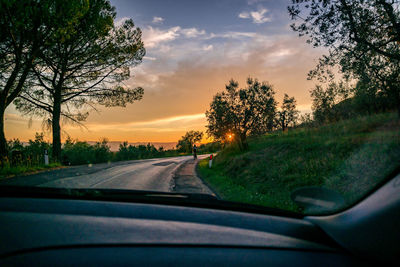 Road seen through car windshield during sunset