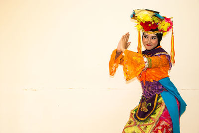 Full length of smiling woman standing against multi colored background