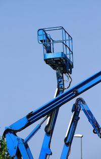 Low angle view of ferris wheel against clear blue sky