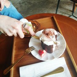 High angle view of woman holding ice cream in plate