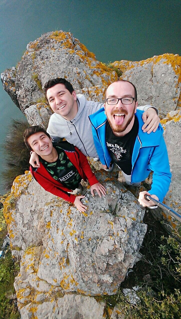 leisure activity, lifestyles, person, casual clothing, full length, childhood, smiling, togetherness, boys, portrait, looking at camera, sitting, rock - object, happiness, front view, bonding, elementary age