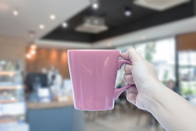 Close-up of hand holding coffee cup