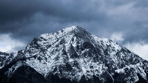 Low angle view of snowcapped mountains against sky