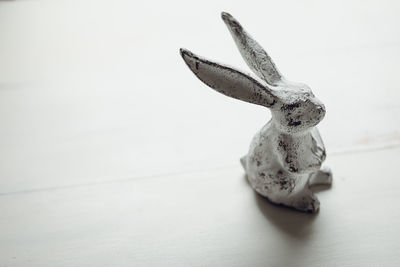 Metal rabbit figurine isolated on white background, off center with copy space