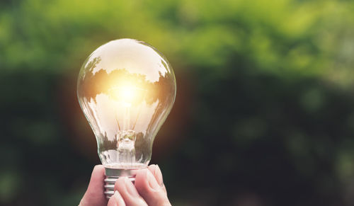 Close-up of hand holding light bulb