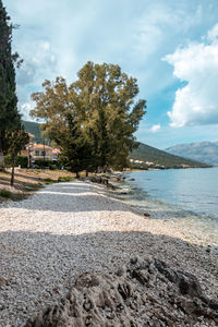 Scenic view of road by sea against sky