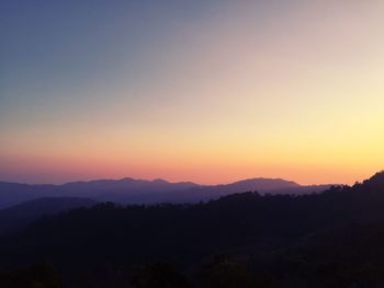 Scenic view of silhouette mountains against sky at sunset