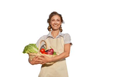 Young woman holding apple against white background