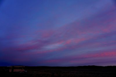 Scenic view of silhouette field against sky at sunset