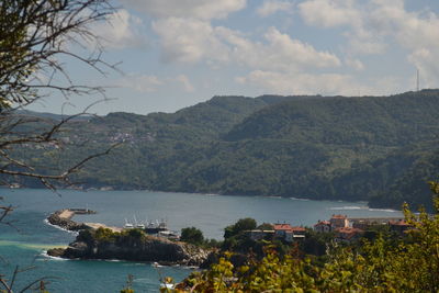 Scenic view of sea and mountains against sky
