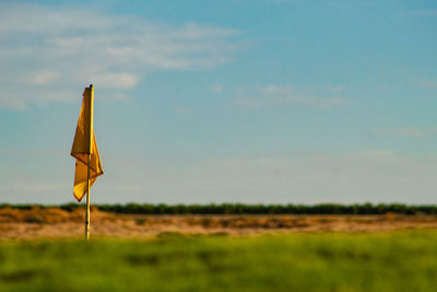 Blue sky over golf course with flag in foreground