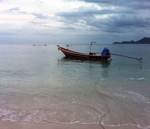 Boat moored on sea against sky