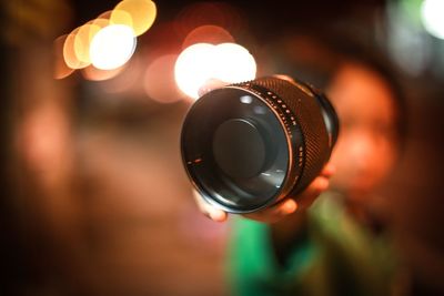 Close-up of hand holding camera lens