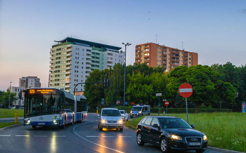Traffic on road in city against clear sky