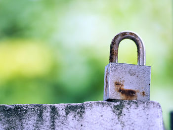 Close-up of padlock on railing against wall