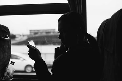 Portrait of woman using mobile phone in bus