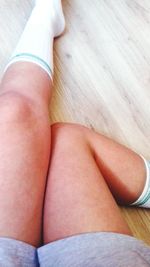 Low section of woman legs on table