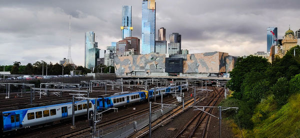 Railroad tracks amidst buildings in city against sky