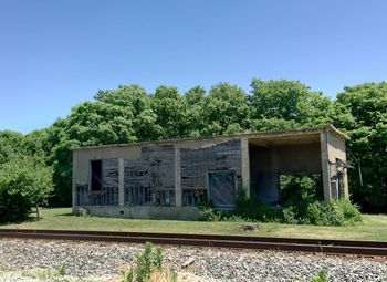 Railroad tracks by trees against clear sky