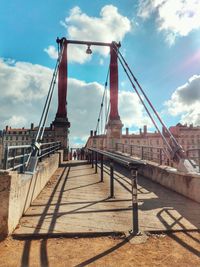 View of suspension bridge against cloudy sky