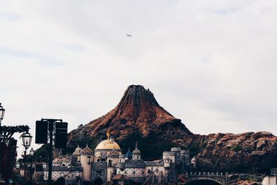 View of buildings in city against cloudy sky