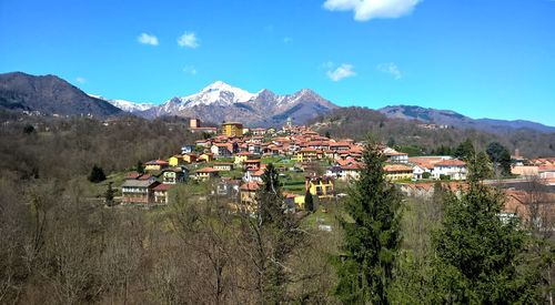 High angle view of residential district by mountains against sky