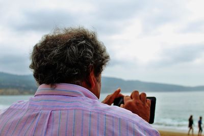 Rear view of man against sea and sky