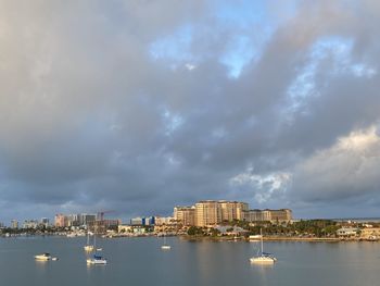 Scenic view of sea by buildings against sky